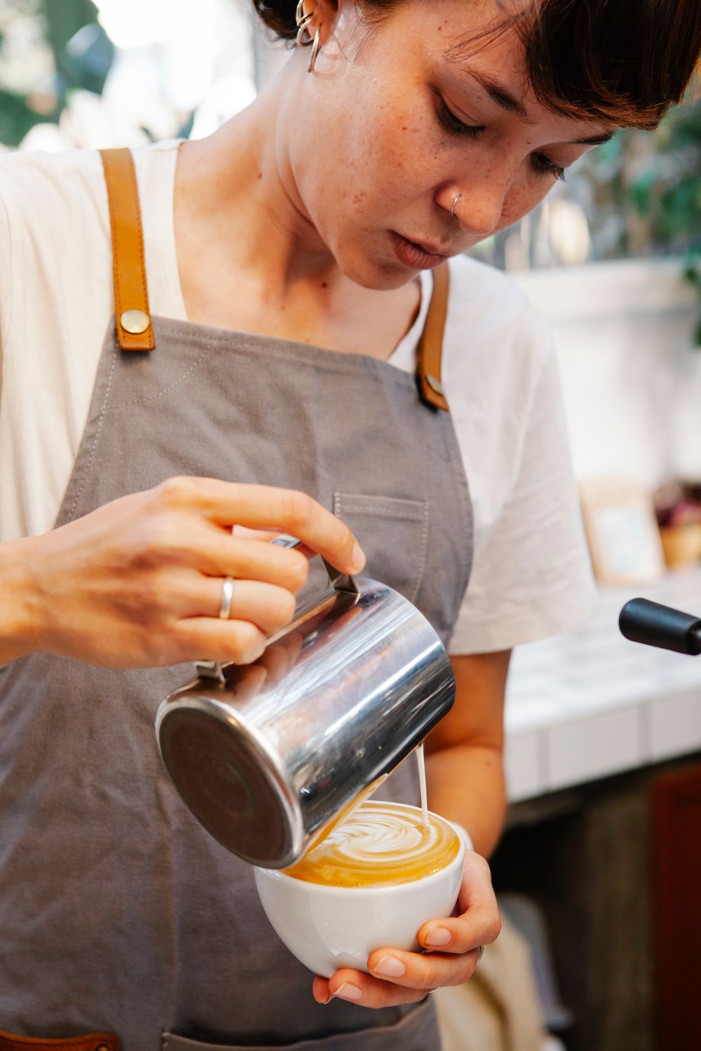 Barista pouring latte art at The Daily Press